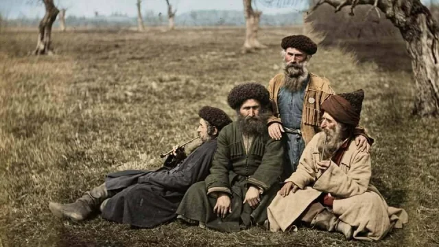 Планински евреи от Кавказ, облечени в традиционни дрехи, седящи на открито в селска среда